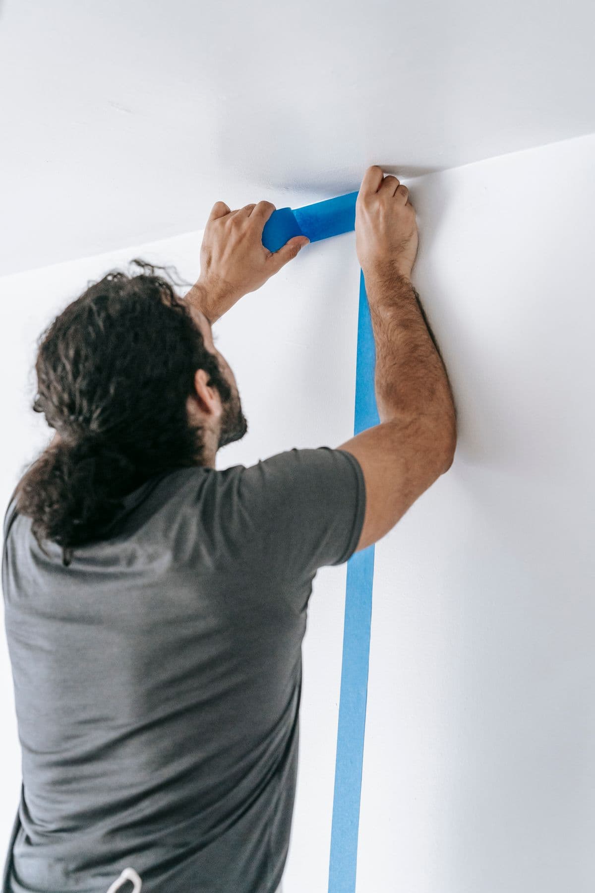 Contractor carefully applying painter’s tape before painting