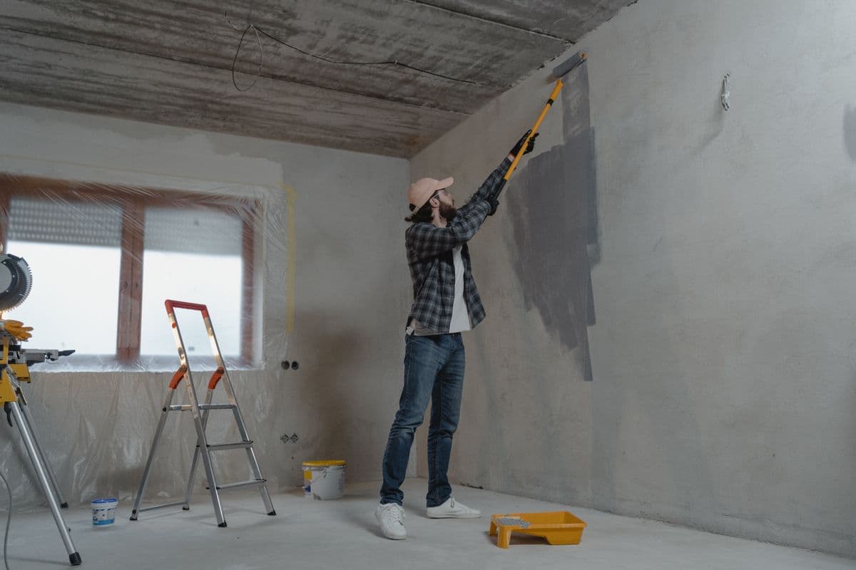 Contractor painting an interior wall during a renovation